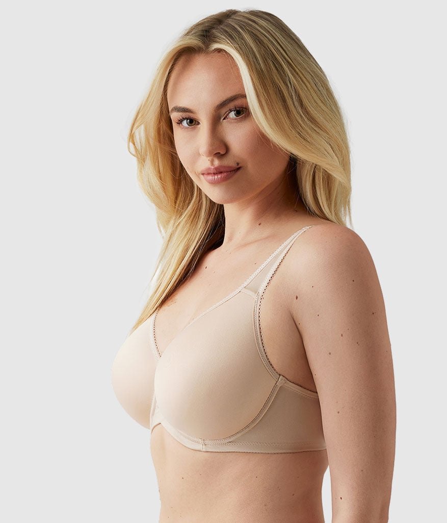 Woman with long blonde hair wearing a beige underwire bra with seamless cups, side view