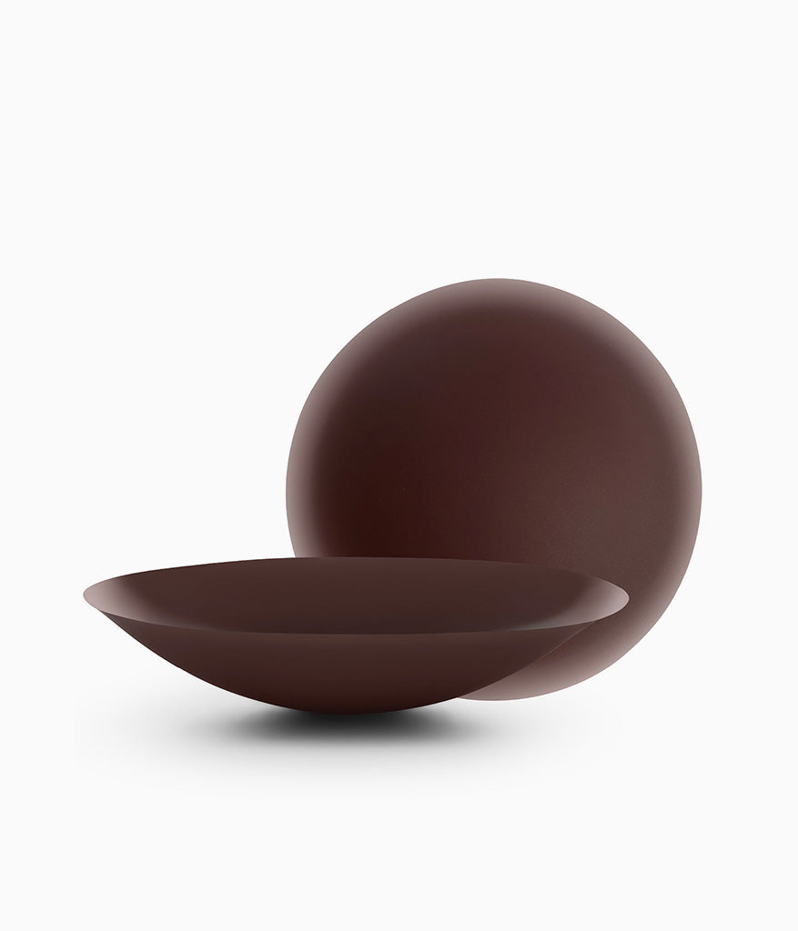 Brown matte bowl and sphere sculptural objects on white surface