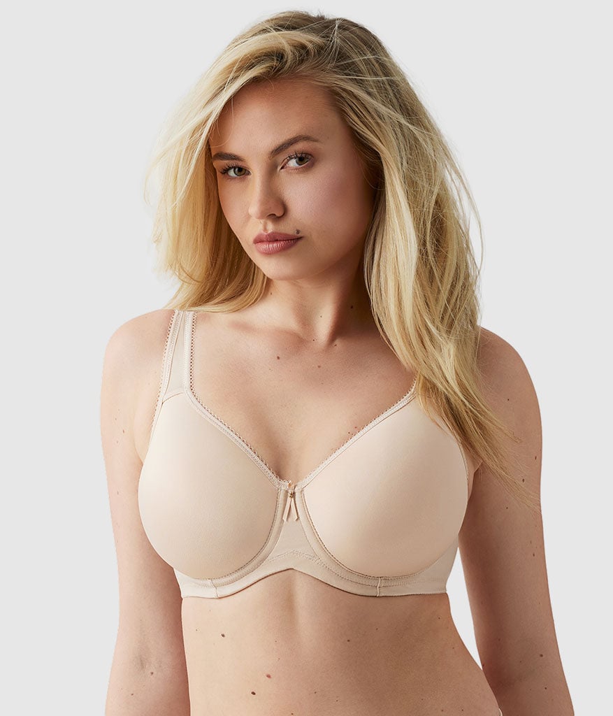 Woman with long blonde hair wearing a beige underwire bra with seamless cups, front view