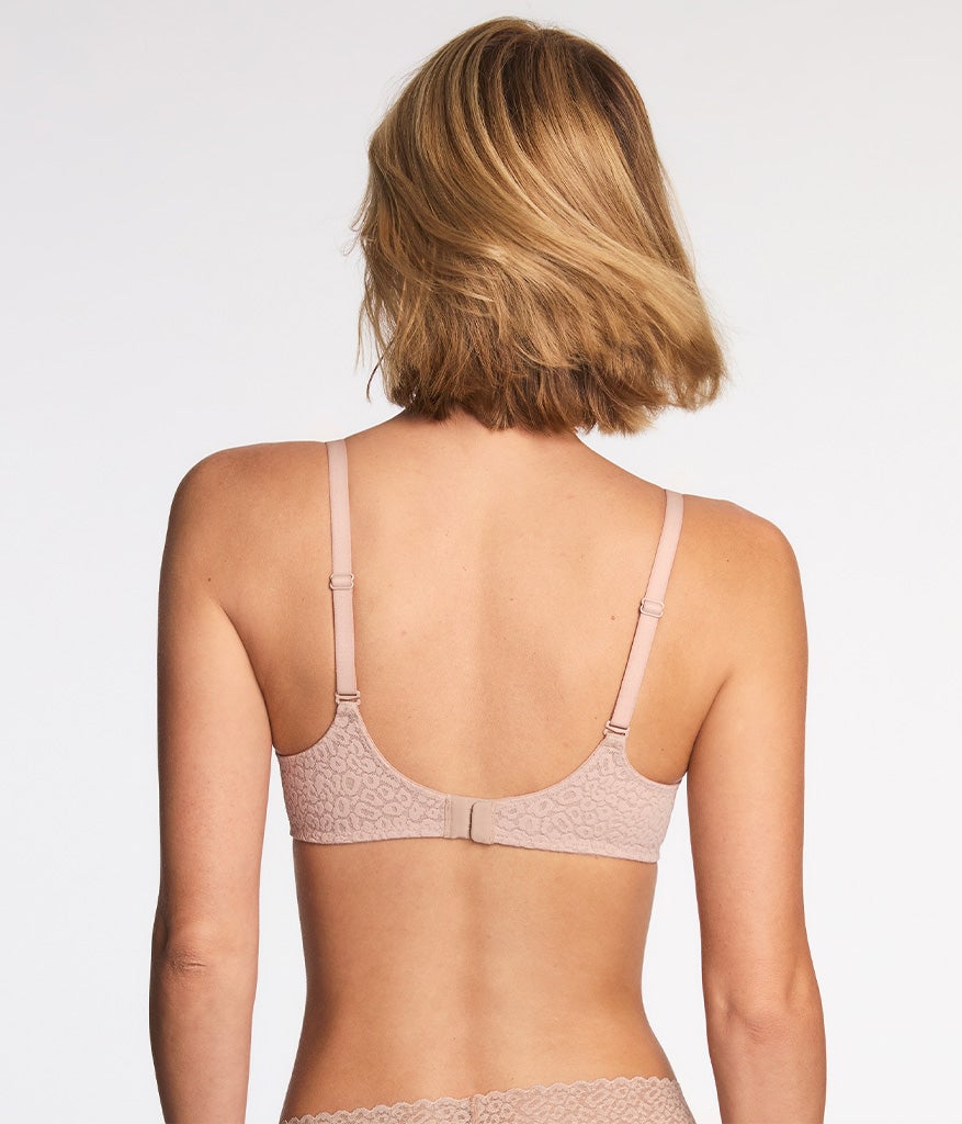 Woman wearing beige lace underwire bra shown from back, displaying strap placement
